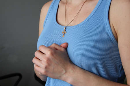 Woman with golden christian cross folded her arms in the prayerの写真素材