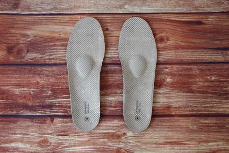 New orthopedic insoles on the wooden background