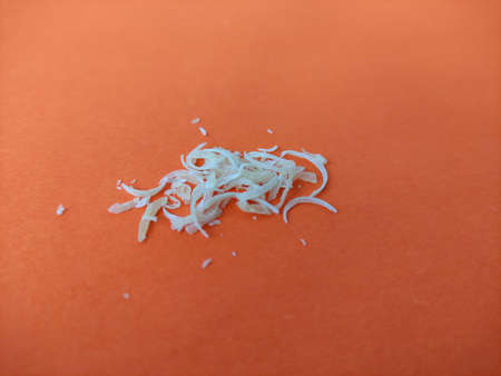 Clipped human nails on the orange background