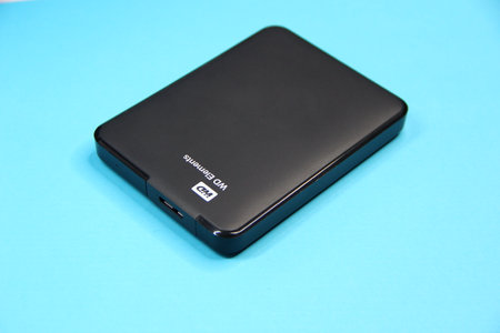Black external hard drive on a blue background, copy spaceのeditorial素材