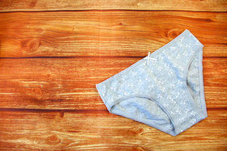 Cotton gray panties on a wooden background with a copy space