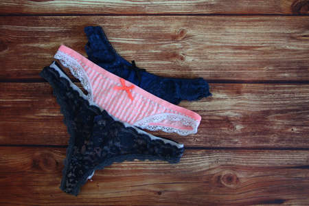 Three colored female lace sexy panties on the wooden background with copyspaceの写真素材