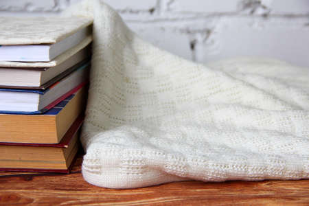 Stack of books and the cozy sweater nearの写真素材