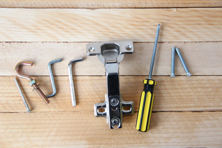 Set of tools and accessories for assembling furniture on a wooden background