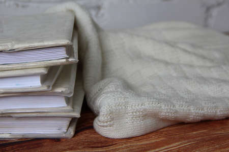 Stack of books and the warm sweater nearbyの写真素材