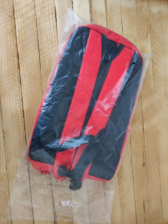 Backpack in package on the wooden background