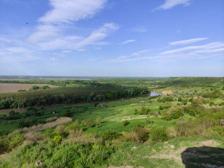 Summer valley with a river, forest, hills and beautiful sky with clouds