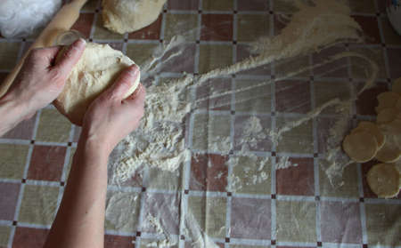 Woman kneading doughin the kitchen, close up