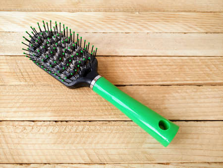 Hairbrush with hair on wooden backgroundの写真素材