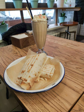 Milkshake with cream and gyros on the table