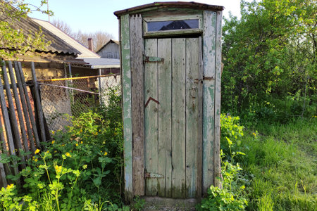 Old rustic wooden toilet in the countryside in summerの写真素材
