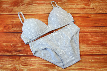 Cotton gray panties and bra on wooden background