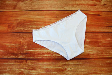Cotton white panties on wooden background with a copy space