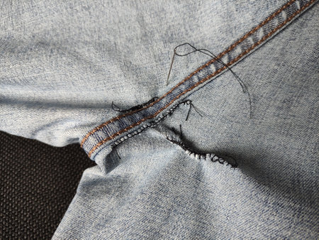 Hand-sewn holes on jeans, seams from sewing on the inside of a denim