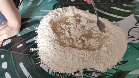 Spreading dough on the table in a kitchenの写真素材