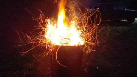 Branches and debris burn in the barrel. A house yard cleaning.の写真素材