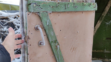 Man closes the door to old village toilet in winter. First person view videoの写真素材