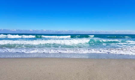 Wave on sand beach on a sunny summer day 
