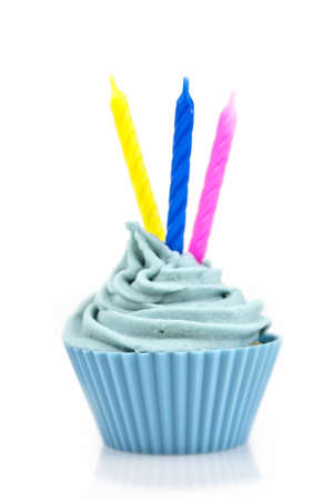 blue cupcake with cream and candle on a pink backgroundの写真素材