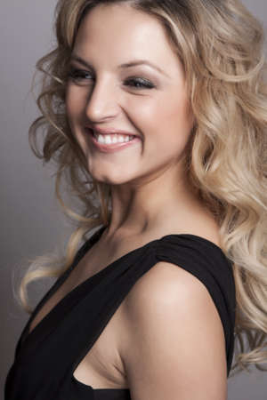 Portrait of beautiful blonde woman on grey background の写真素材