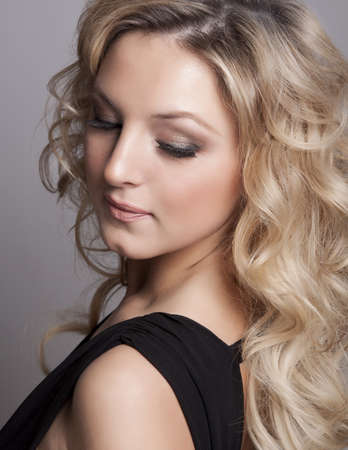 Portrait of beautiful blonde woman on grey background の写真素材