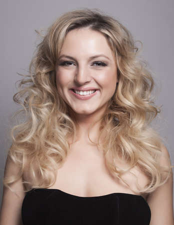 Portrait of beautiful blonde woman on grey background の写真素材