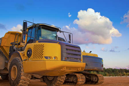 yellow trucks on a field with beautiful blue skyの写真素材