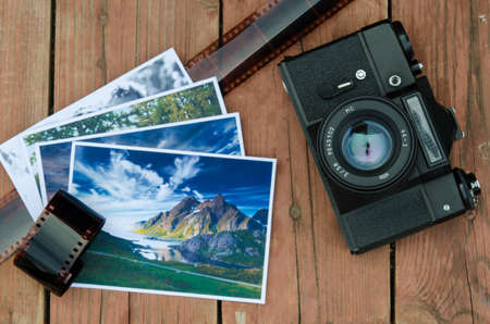 Vintage camera with film and photos on wooden backgroundの写真素材