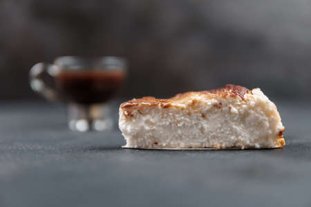 A composition on a dark background. A dessert made with cheese in the form of cake, raspberry...