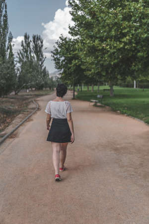 A woman walks during a sunny day in the parkの写真素材