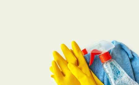 messy home office cleaning service concept.rubber gloves micro fiber cloth and blue color spray...
