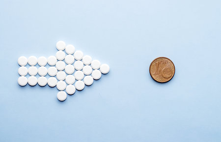 pills isolated medicine medical concept.white round red heart shaped pills chaotic or in row on green blue black orange paper from bottle disease treatment.arrow from tablets money coin plastic blisterの写真素材