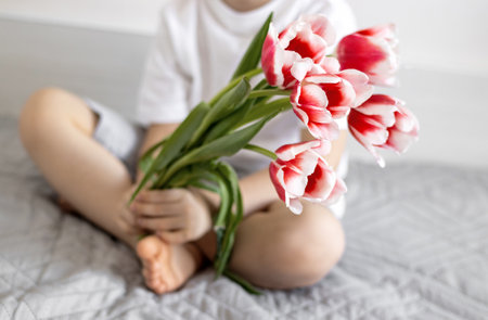 tulips on jeans and spring calling on smartphone kid holding flowerの写真素材