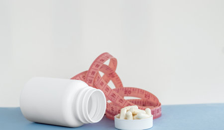 white pills bottle with vitamin c capsules with stethoscope and measure tapeの写真素材