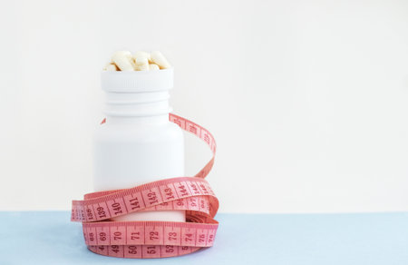 white pills bottle with vitamin c capsules with stethoscope and measure tapeの写真素材