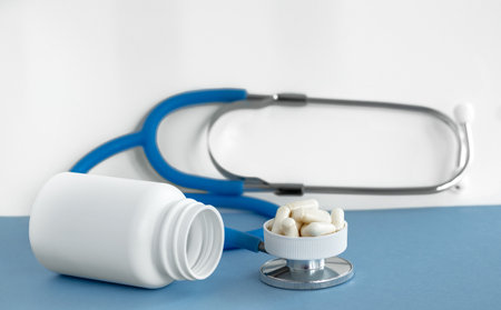 white pills bottle with vitamin c capsules with stethoscope and measure tapeの写真素材