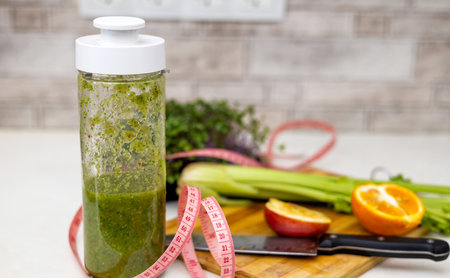 woman do healthy smoothie at kitchen, weight loss concept, measure tapeの写真素材