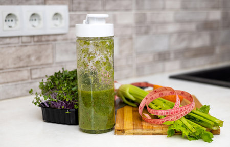 woman do healthy smoothie at kitchen, weight loss concept, measure tapeの写真素材