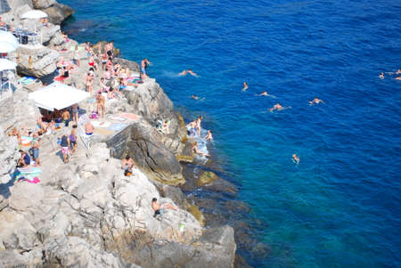Popular beach bar on the cliffs. Clients sunbathing and swimming. Dubrovnik, Croatiaのeditorial素材