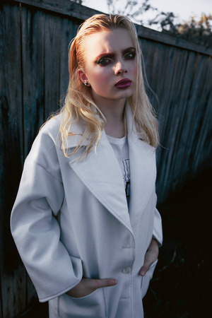 Beautiful girl in white dress with curly hair on grunge backgroundの写真素材