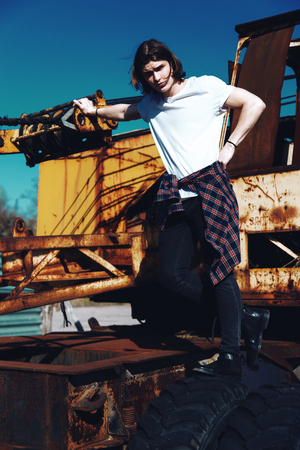 Beautiful boy in white t-shirt with long hair on grunge backgroundの写真素材