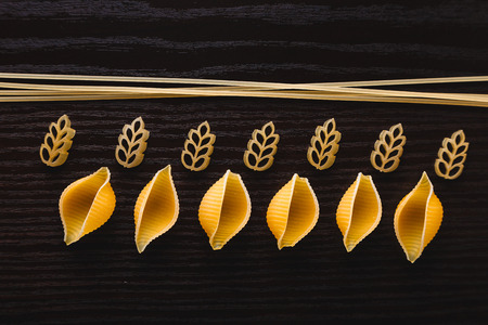 Mound pasta on dark wooden background close-up macro