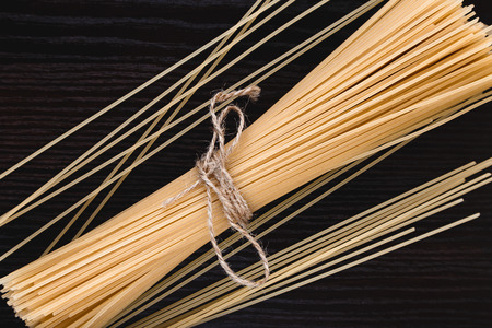 Mound pasta on dark wooden background close-up macro
