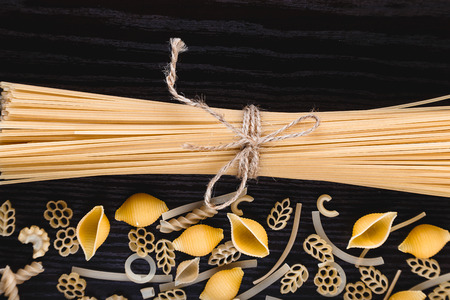 Mound pasta on dark wooden background close-up macro