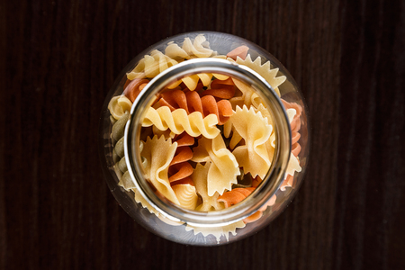 Pasta in a jar on a dark wooden background