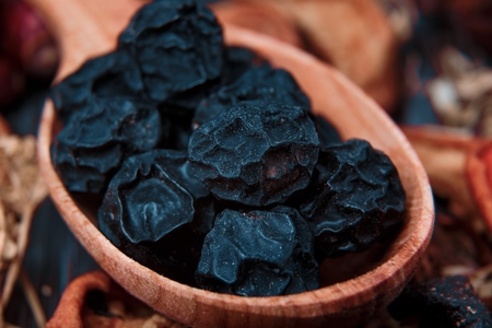 Dried fruit and berries in a wooden bowl on sacking background close-up macroの写真素材