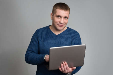 Portrait of handsome guy using laptop computerの写真素材
