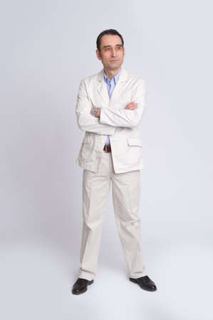 Full length portrait businessman in suit isolated over gray backgroundの写真素材
