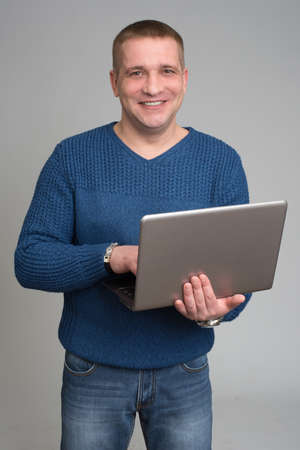 Happy Man Working On Laptop On Grey Backgroundの写真素材