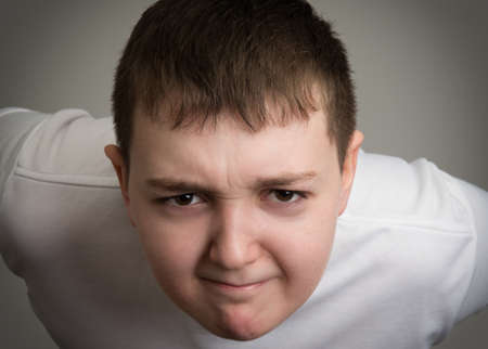 Portrait of boy looking up isolated on a gray backgroundの写真素材
